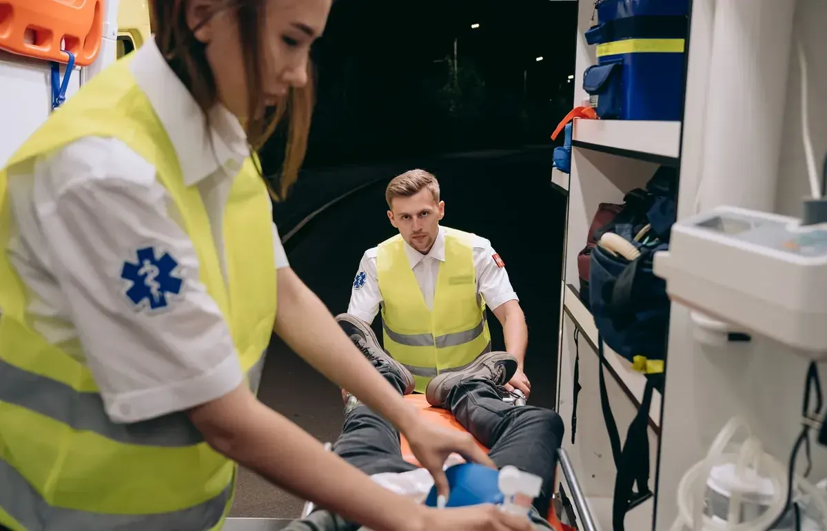 Paramedics providing supervised emergency care inside an ambulance