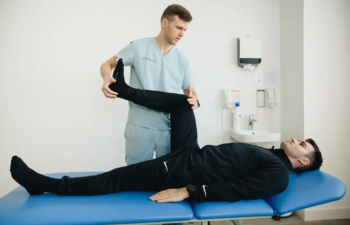 Physiotherapist guiding a patient through a supervised rehabilitation exercise